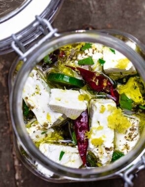 marinated feta in a jar with olive oil, dry chiles, sliced jalapeno, and orange zest