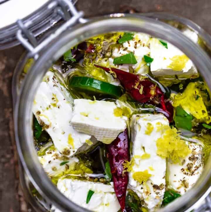marinated feta in a jar with olive oil, dry chiles, sliced jalapeno, and orange zest