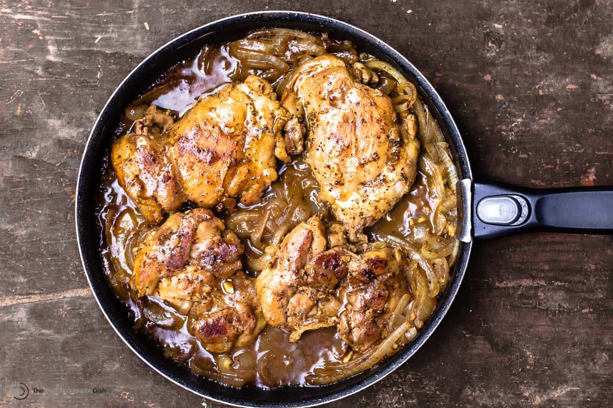 chicken thighs in a skillet with onions