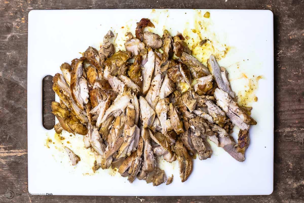 shredded chicken thighs on a cutting board