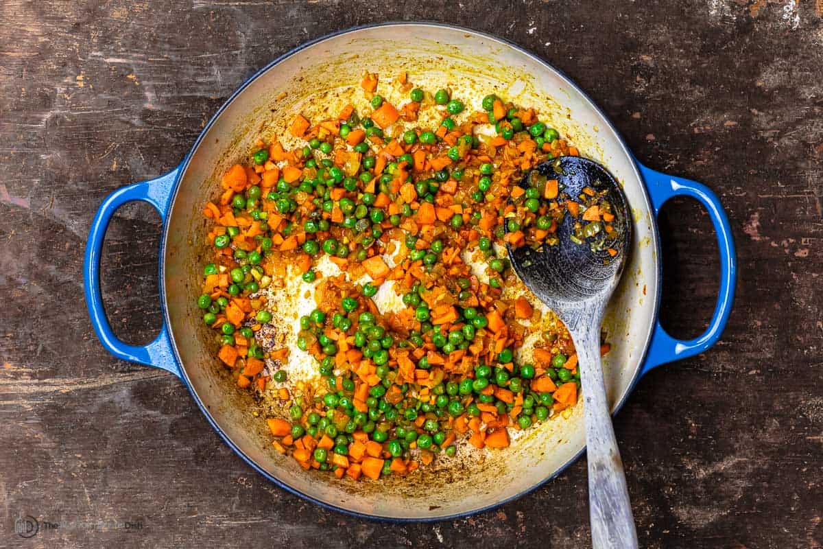 peas and carrots sautéing with onions and carrot