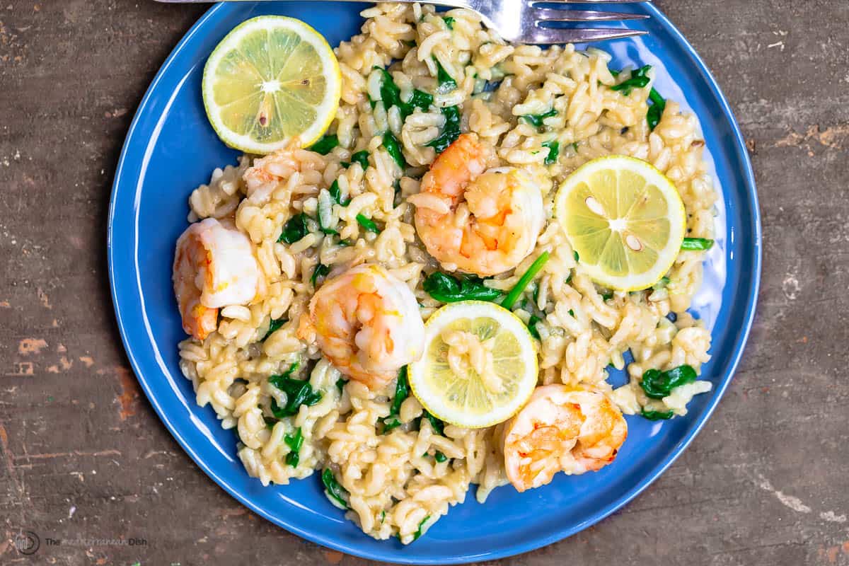 Shrimp risotto with spinach, topped with lemon slices