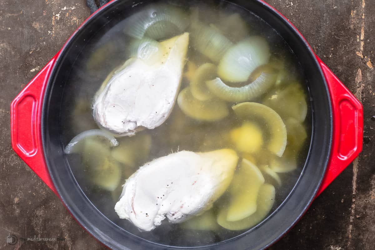 chicken breasts boiling with onions