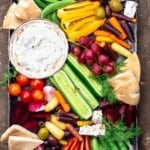 Crudite and tztaziki sauce with pita wedges on a platter