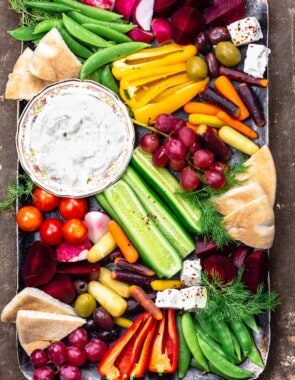 Crudite and tztaziki sauce with pita wedges on a platter