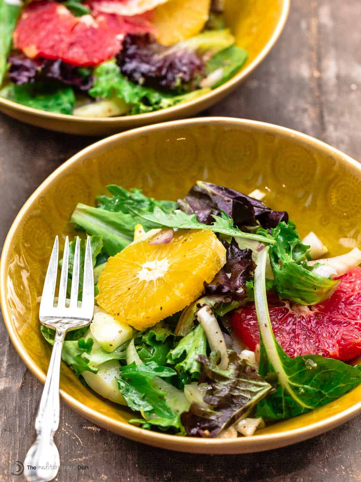 citrus salad in a yellow bowl with a fork