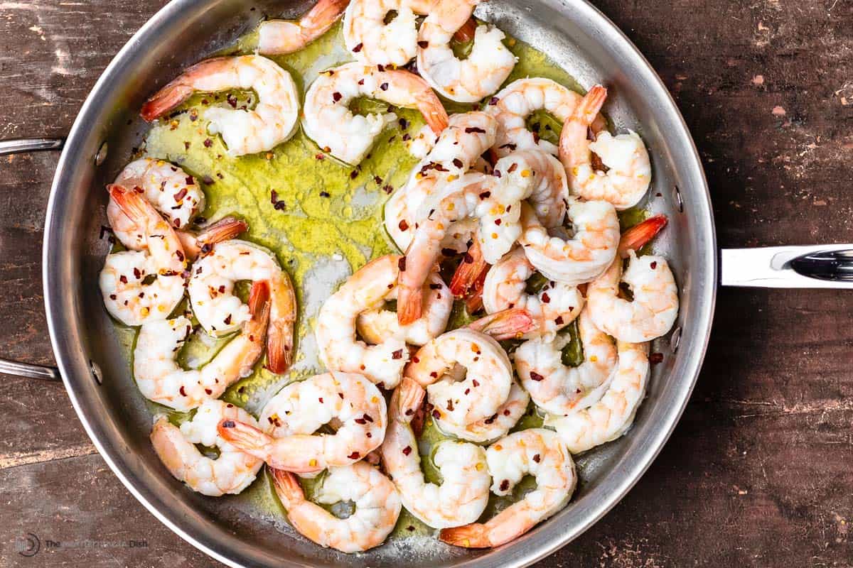 shrimp in a skillet with olive oil and red pepper flakes