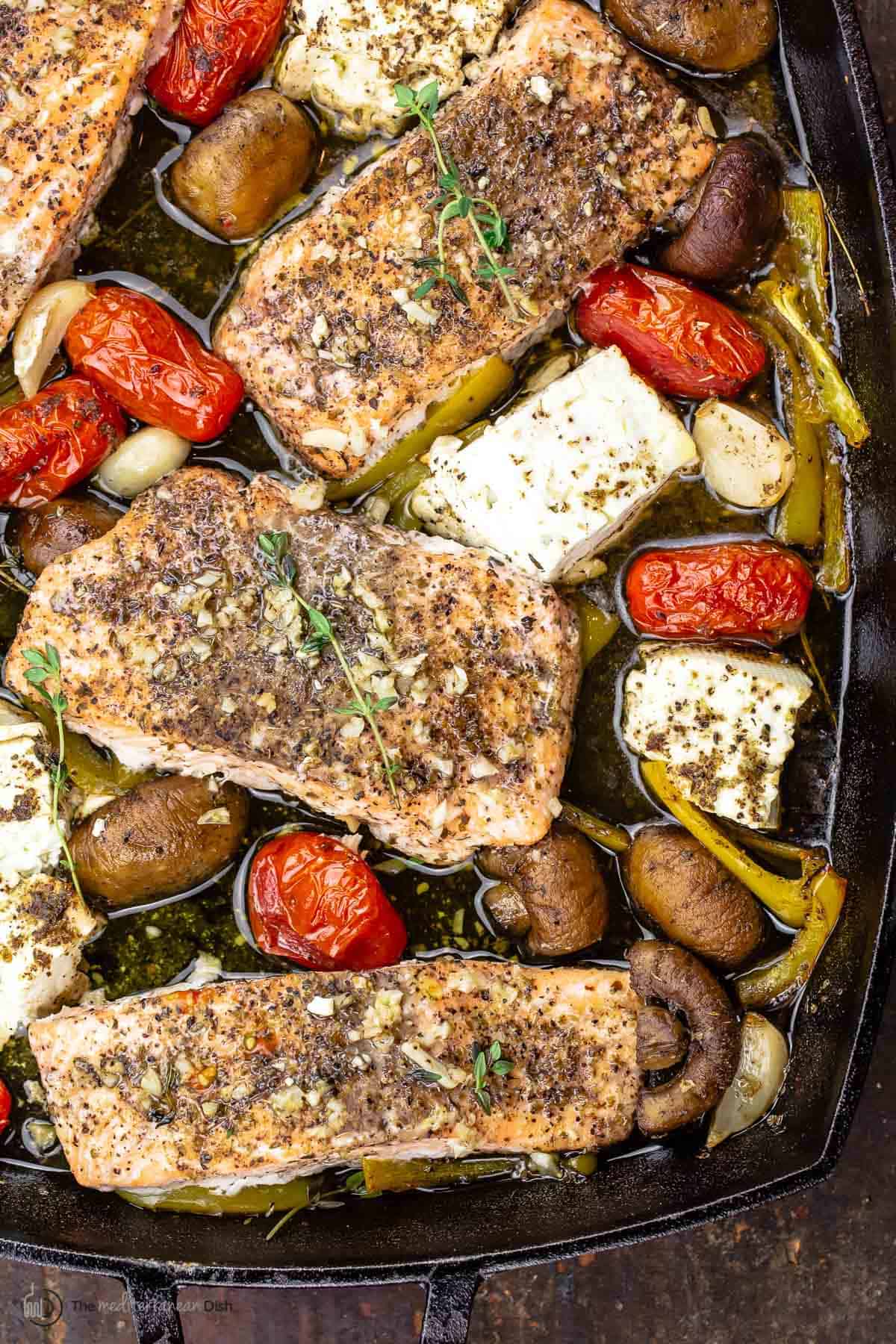 baked salmon with feta and vegetables in a baking dish