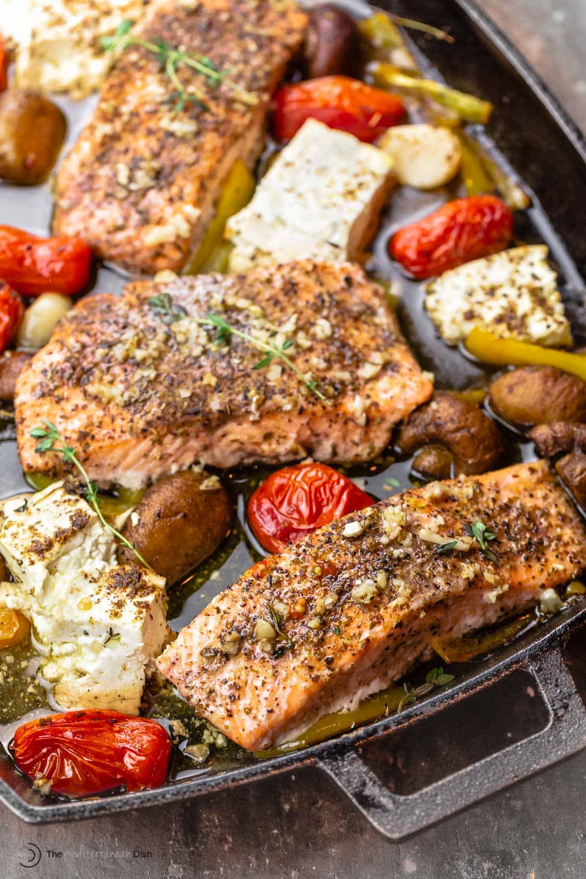 baked salmon fillet with mushrooms, feta, cherry tomatoes, garlic, and bell peppers