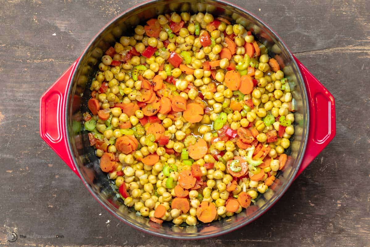 step image of chickpea soup with carrots, bell peppers, celery, onions, and spices