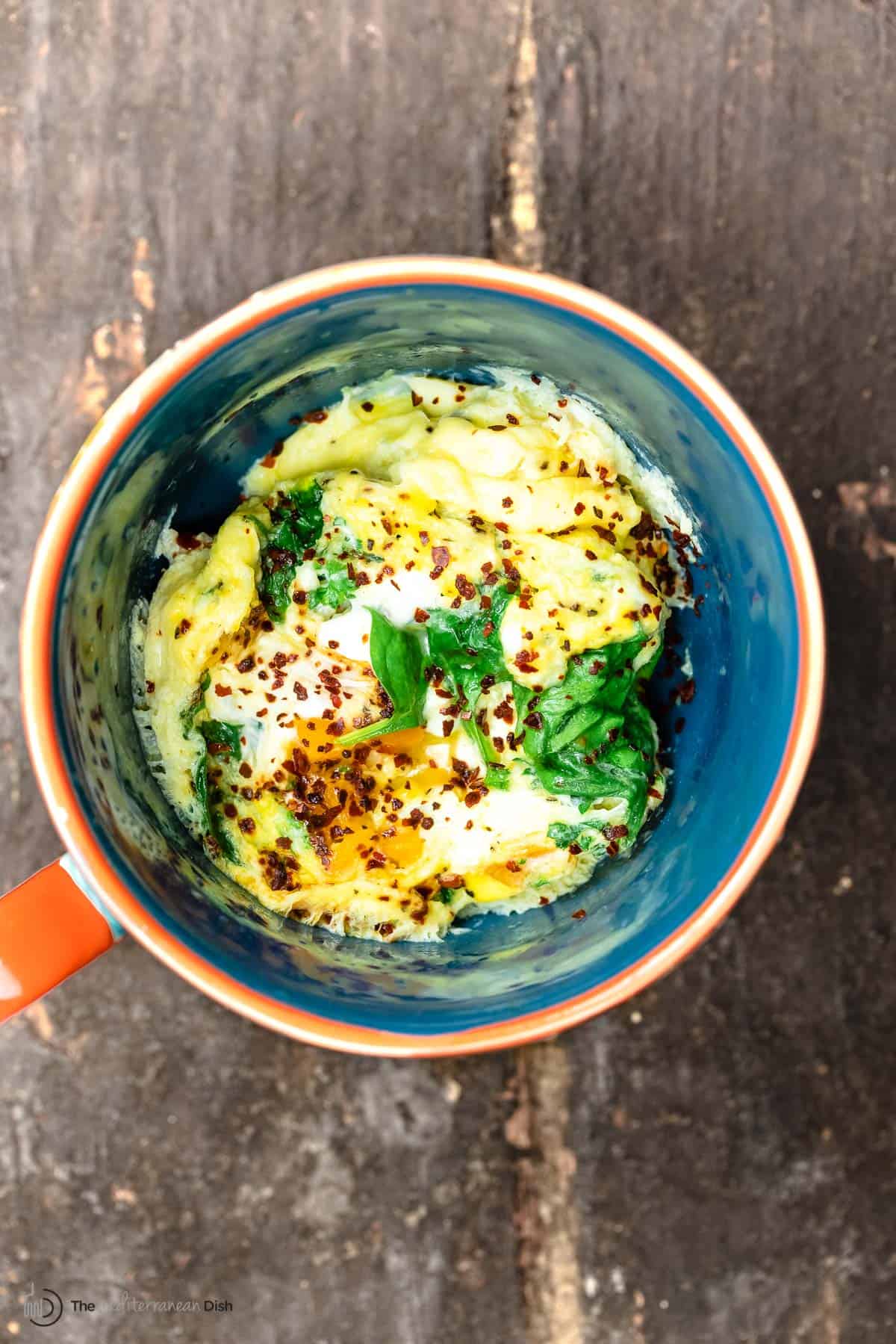 one mug with a cooked omelet and veggies