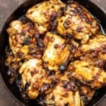 Onion chicken thighs in a cast iron skillet