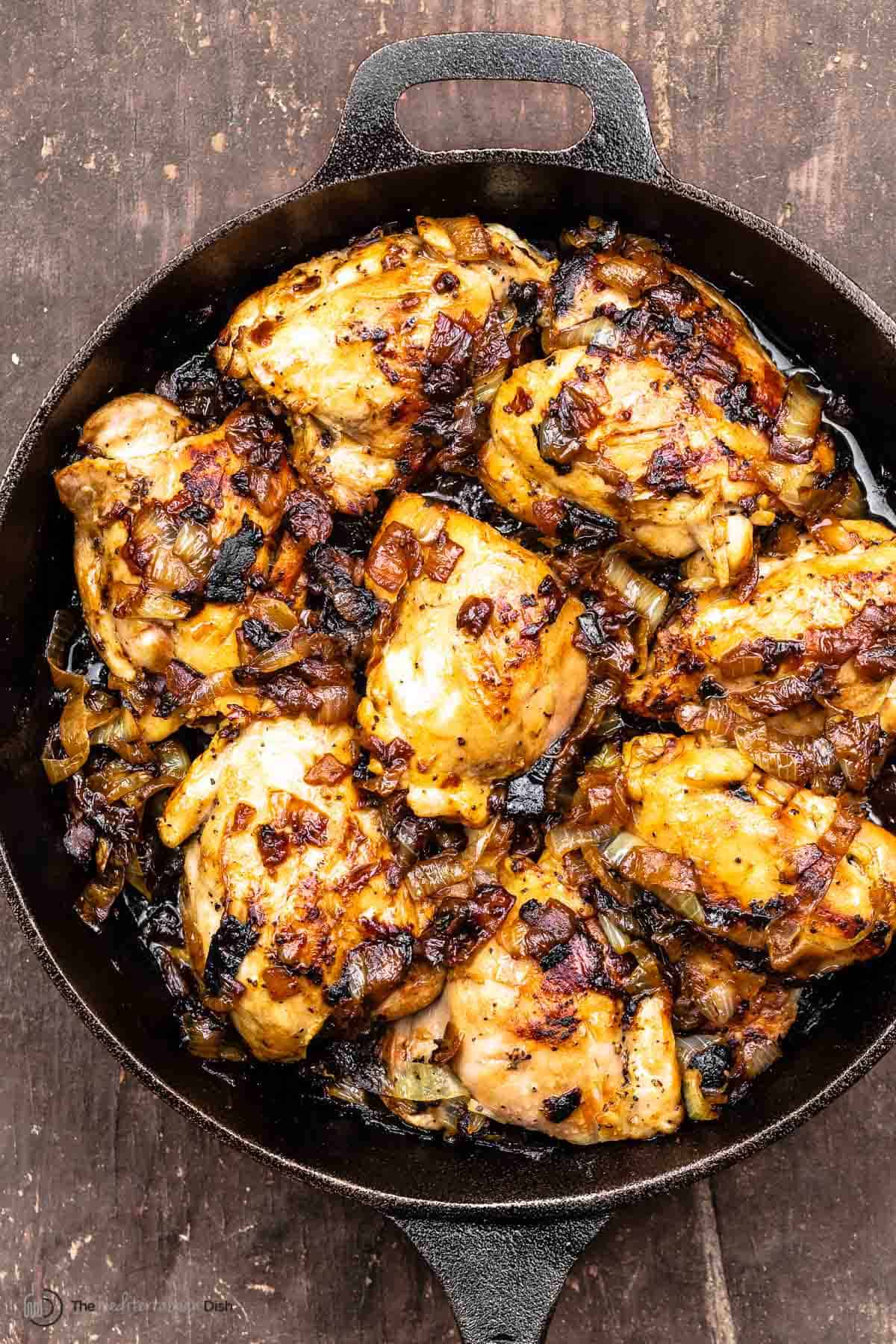 Onion chicken thighs in a cast iron skillet