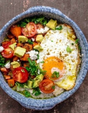 savory oatmeal bowl with cherry tomatoes, avocado, parsley, feta cheese, and za'atar