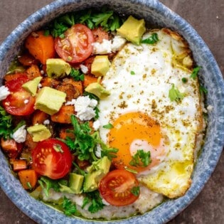 savory oatmeal bowl with cherry tomatoes, avocado, parsley, feta cheese, and za'atar