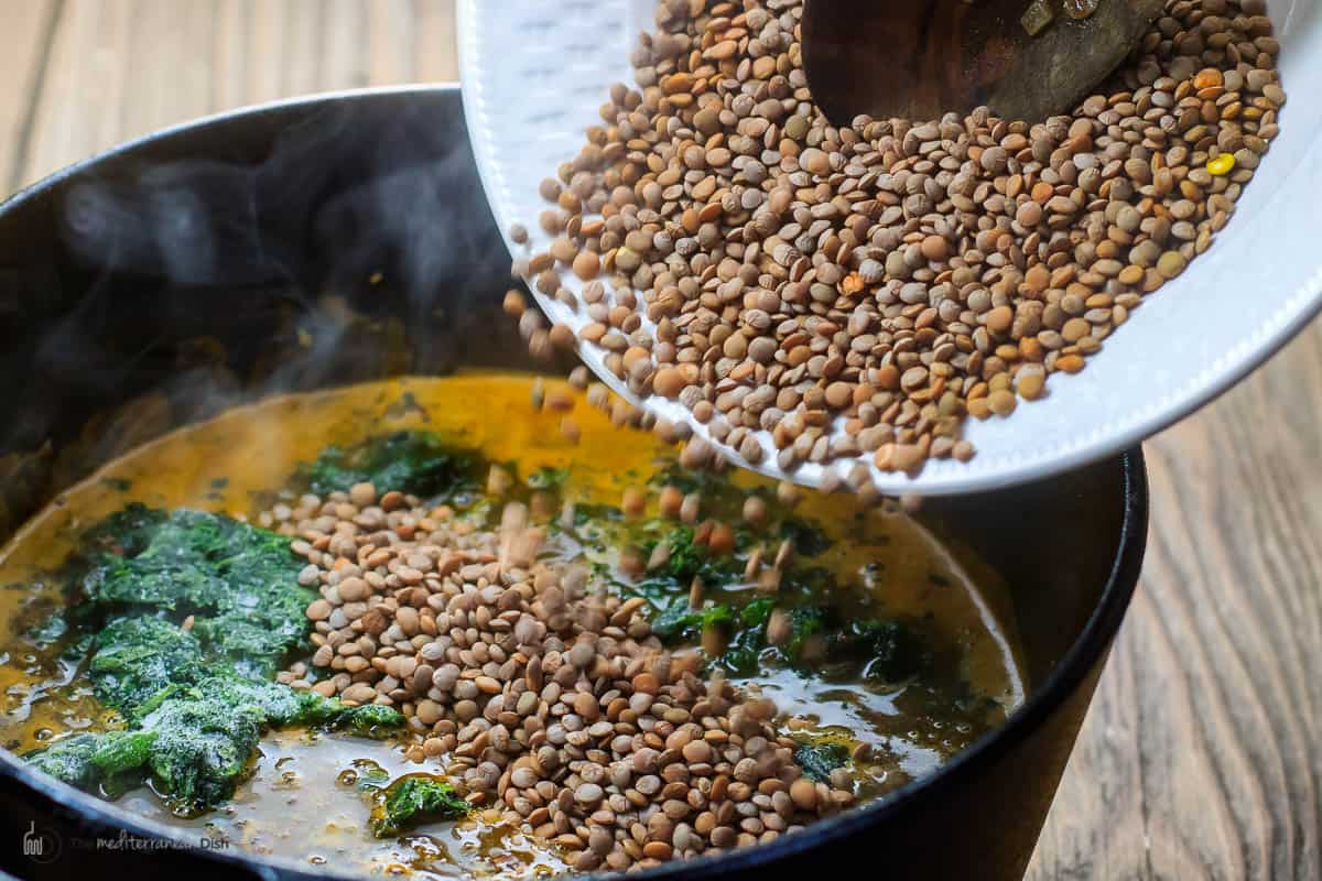 lentils added to pot with liquid and frozen spinach
