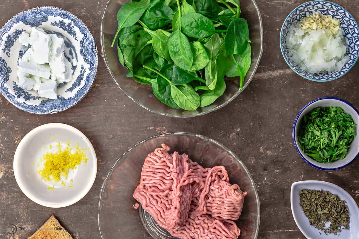 ingredients for turkey meatballs including meat, spinach, feta, onions, garlic and herbs