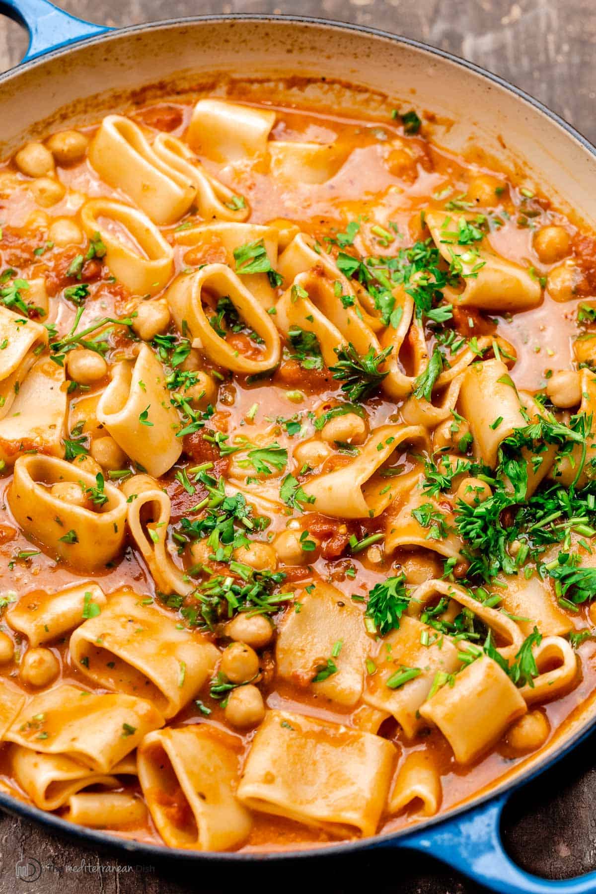 close up of creamy tomato pasta with chickpeas in the pan with pink sauce