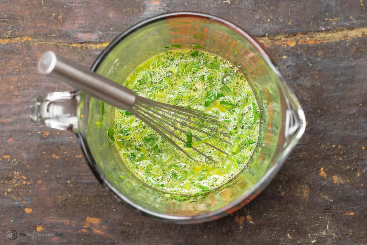 eggs beaten with a whisk and mixed with fresh herbs in a large measuring jug