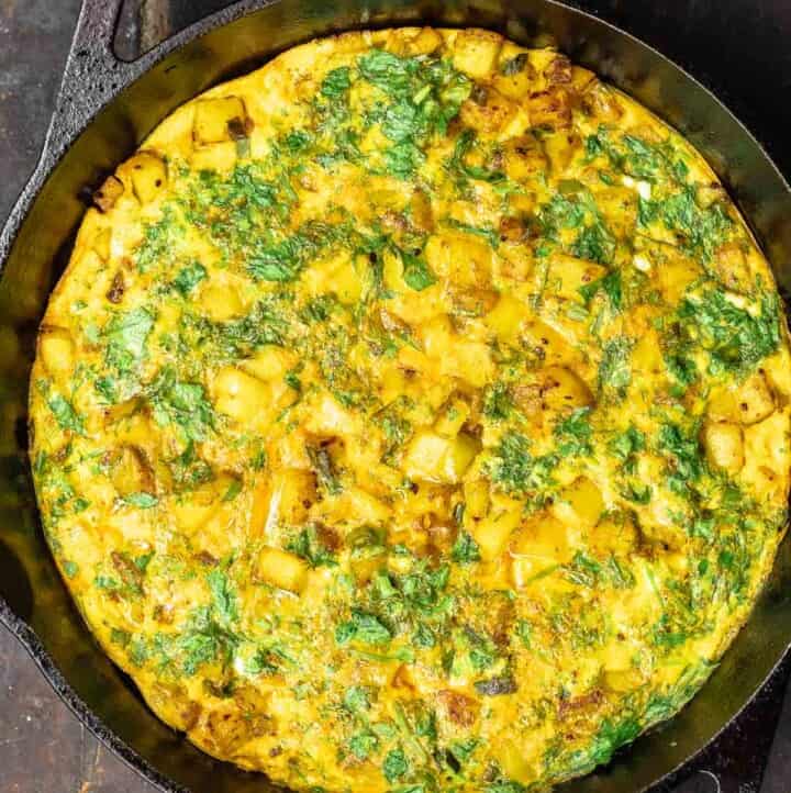 herby potato omelet in a skillet