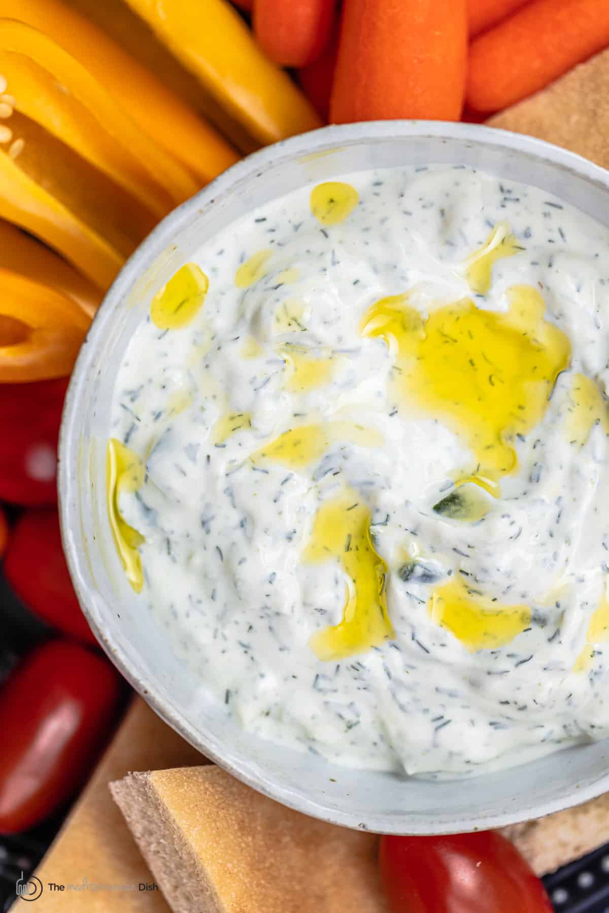 Tzatziki Sauce | The Mediterranean Dish Tzatziki cucumber yogurt sauce in a bowl with a side of sliced vegetables