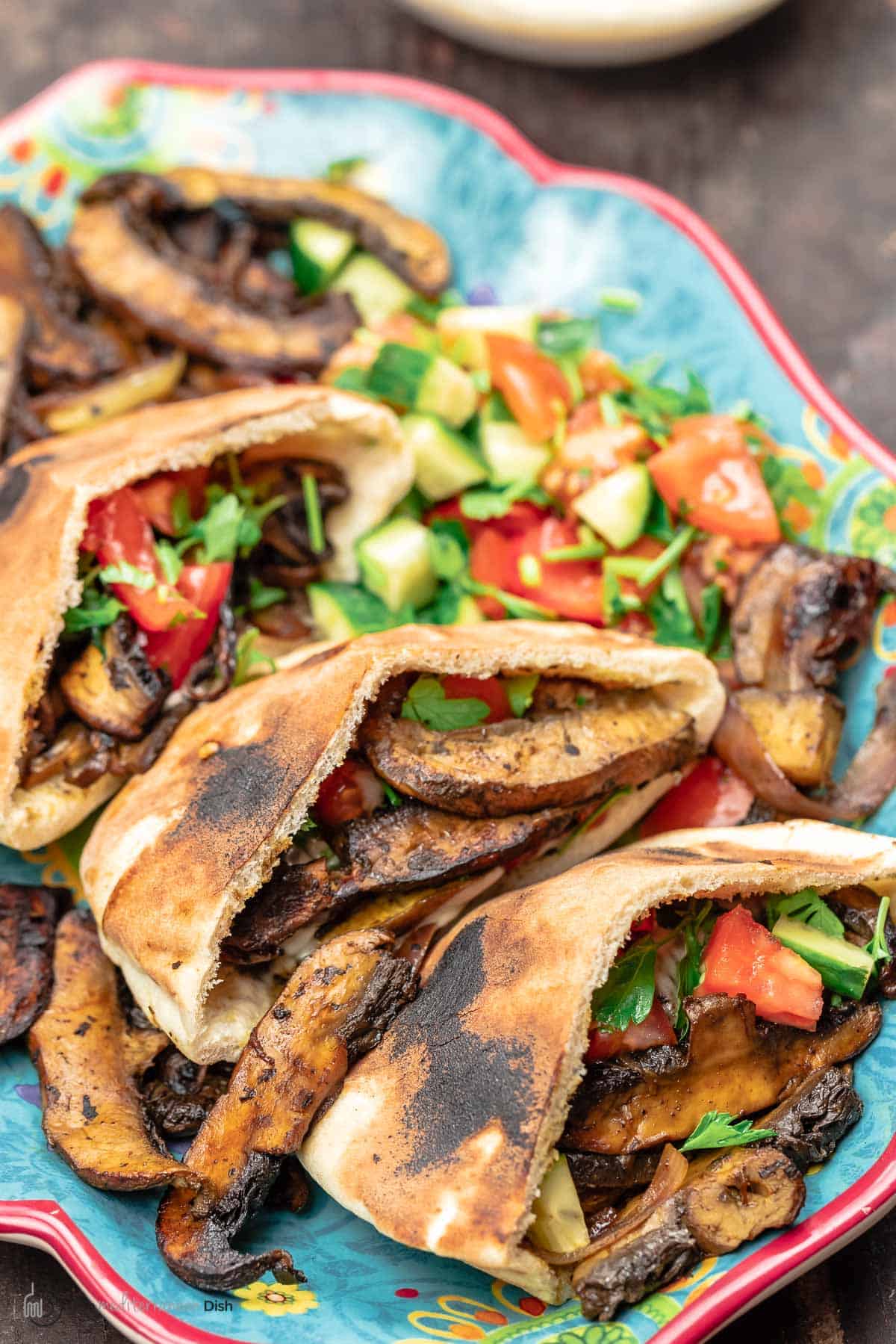 vegan shawarma with mushrooms in pita alongside a Mediterranean salad