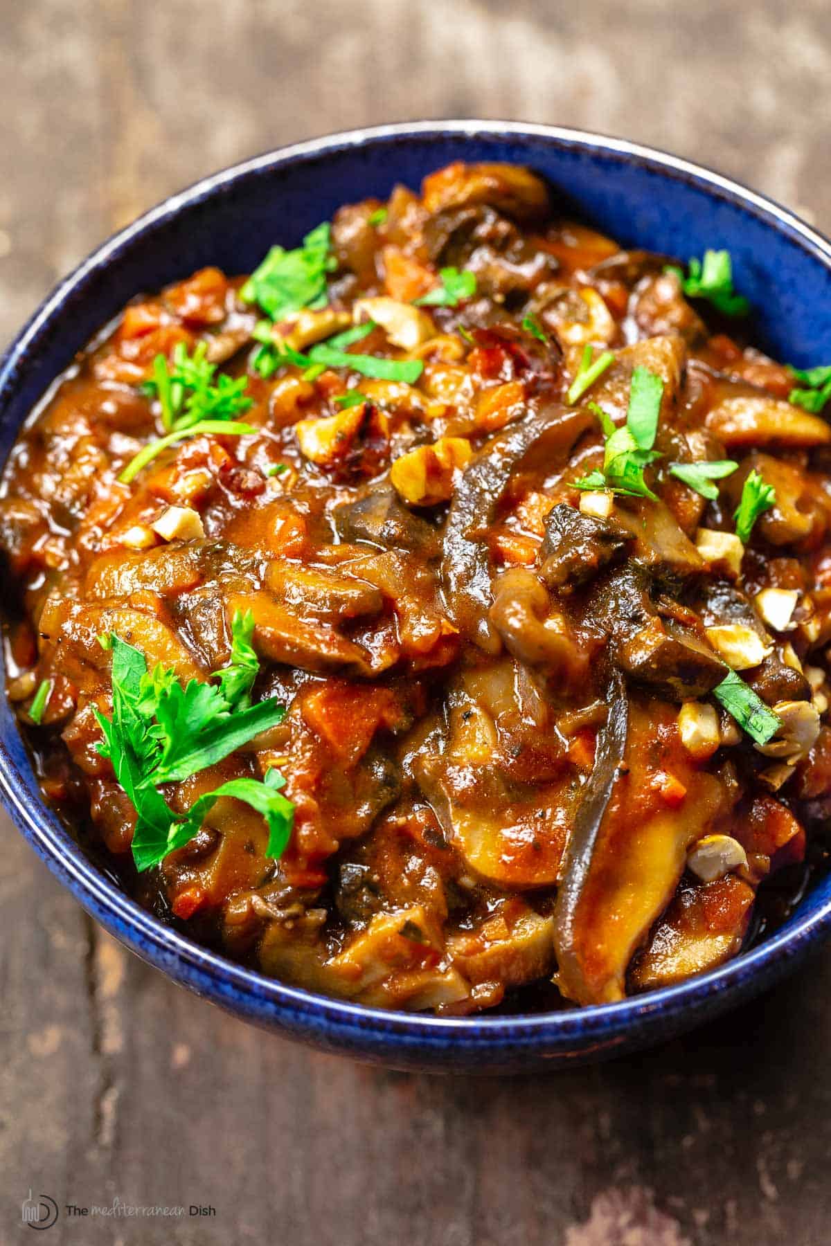 mushroom ragu topped with fresh parsley in a blue bowl