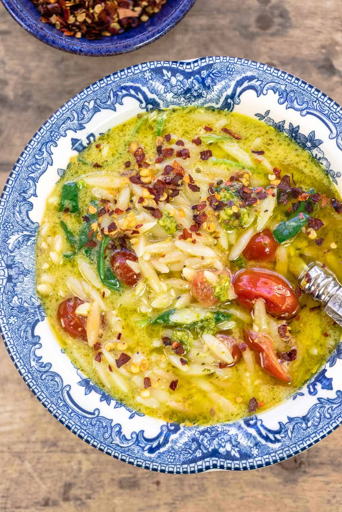 soup in a blue and white bowl, topped with red pepper flakes