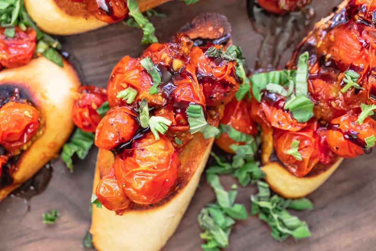 close up of bruschetta with tomatoes, fresh basil and balsamic glaze