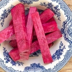 sliced turnip pink pickles in a small blue and white bowl