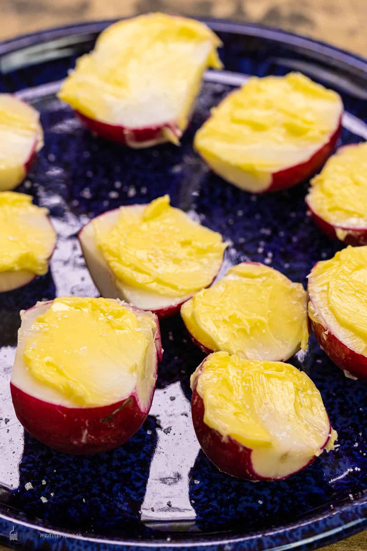 Radish halves with butter spread on top and salt