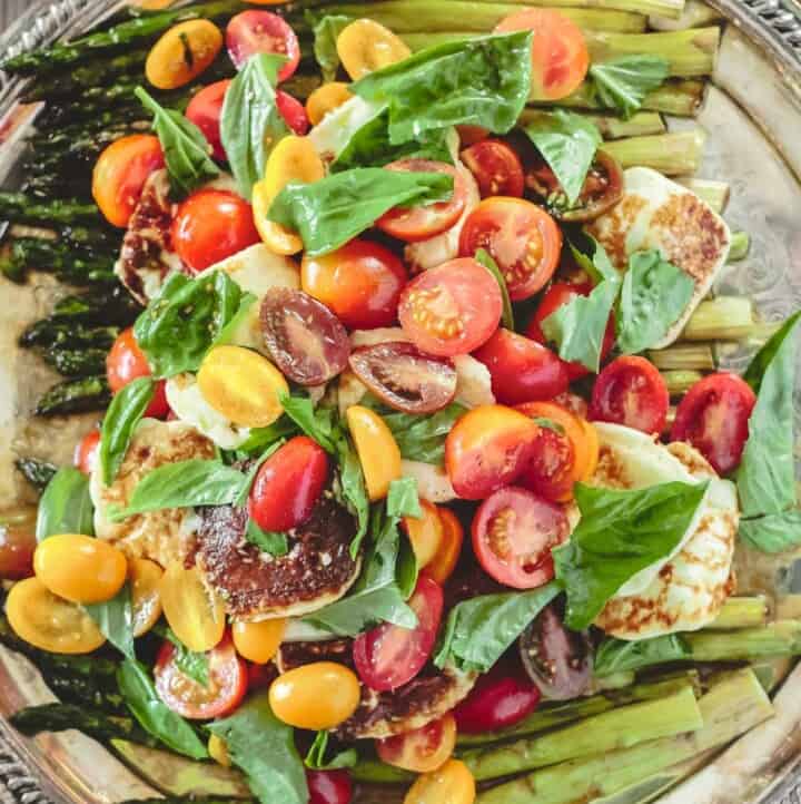 roasted asparagus salad with cherry tomatoes, halloumi cheese, and basil leaves