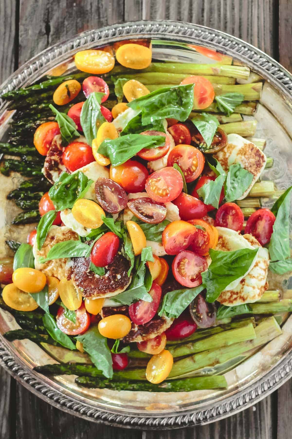 roasted asparagus salad with cherry tomatoes, halloumi cheese, and basil leaves