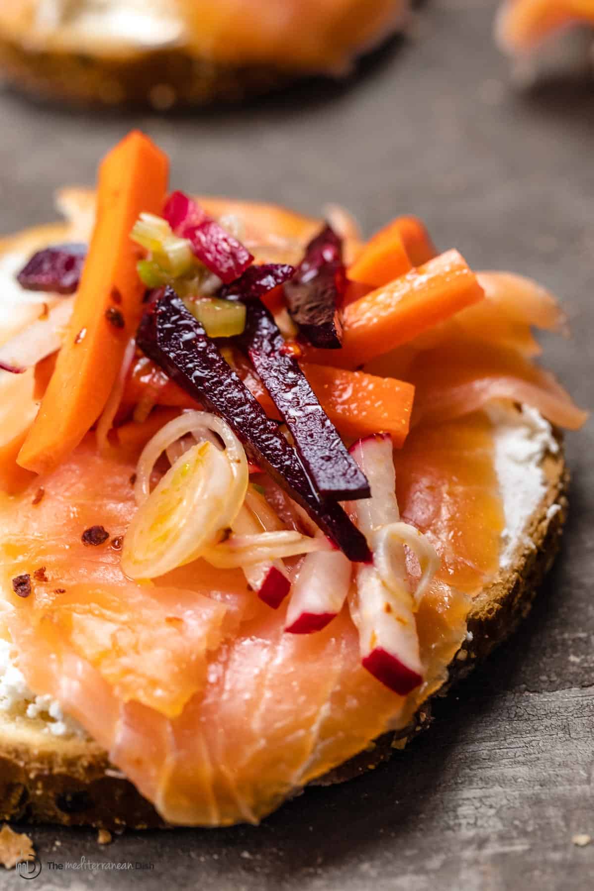 smoked salmon over toast with feta and root vegetables like carrots and beets