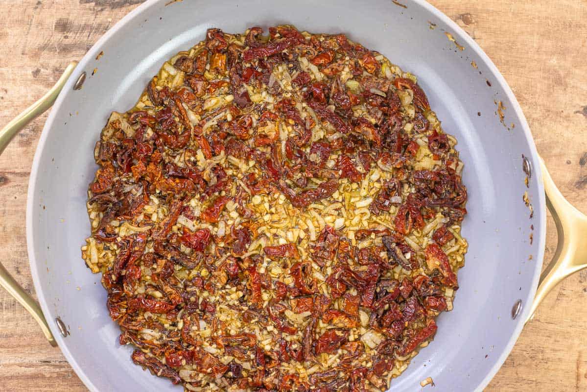 échalotes, ail et tomates séchées dans une grande poêle