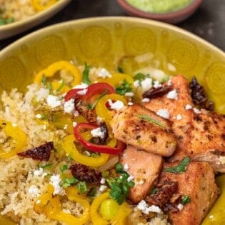 salmon rice bowls with colorful vegetables like bell peppers in a yellow bowl