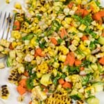 close up of summer corn salad with fresh vegetables and herbs on a plate.