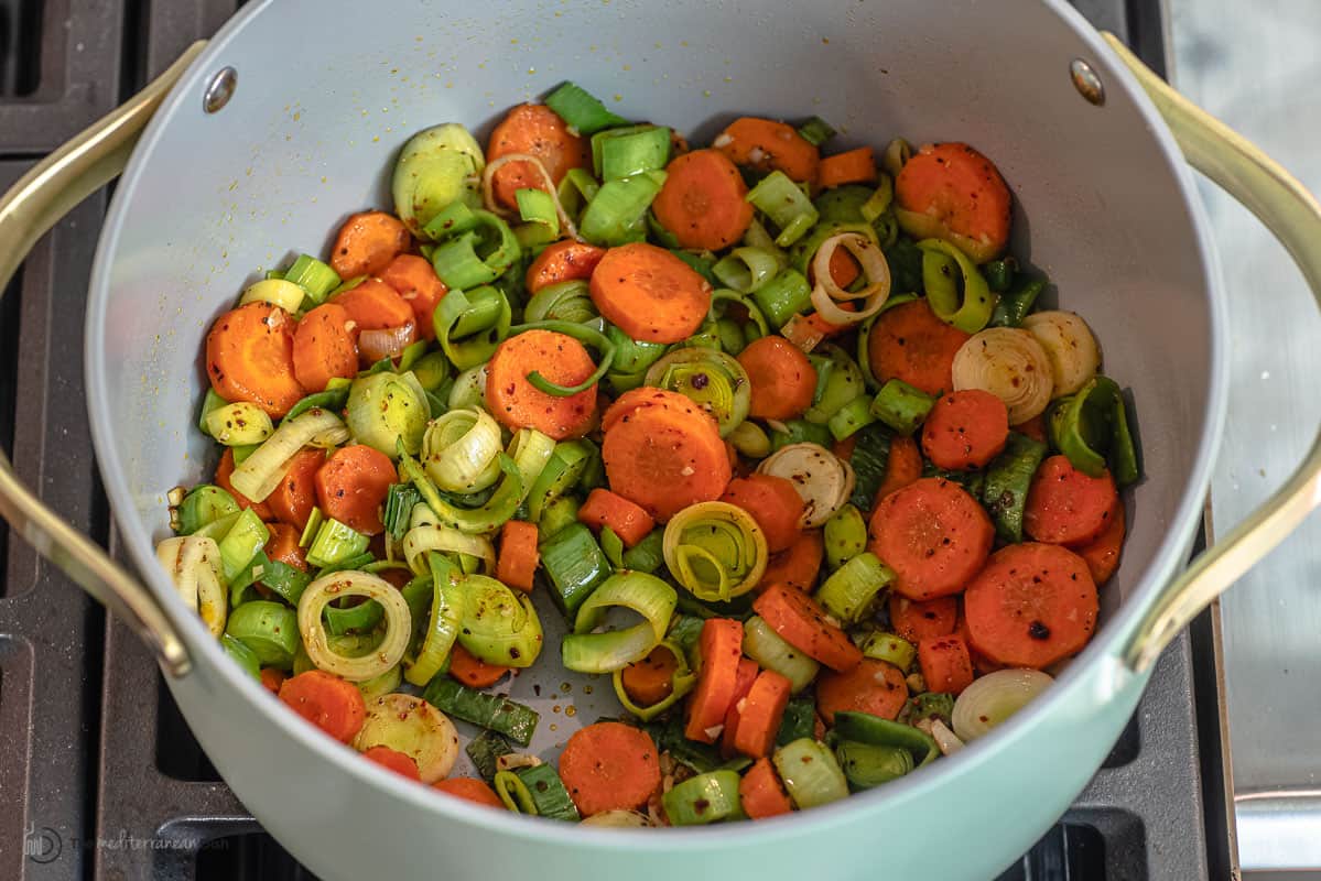 leeks, carrots, and spices in a large saucepan.