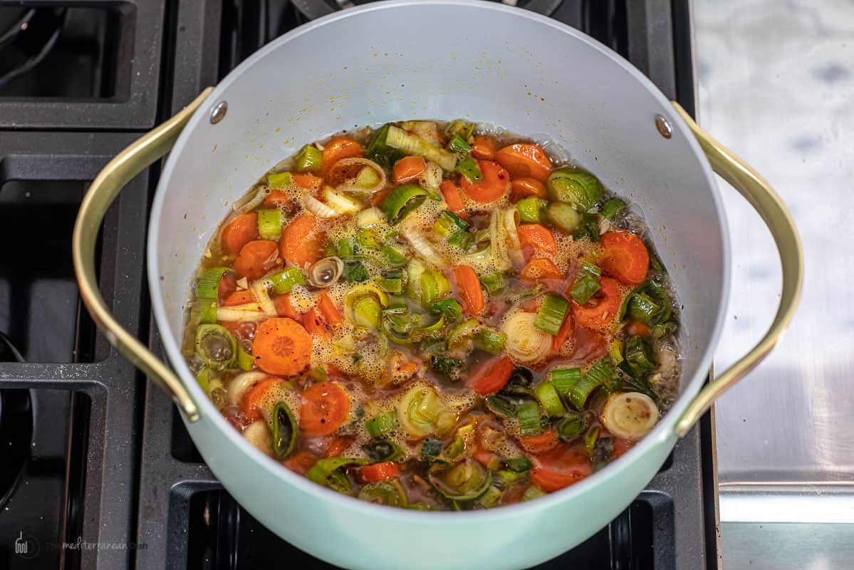 Turkish-style leeks braising in water in a large saucepan.