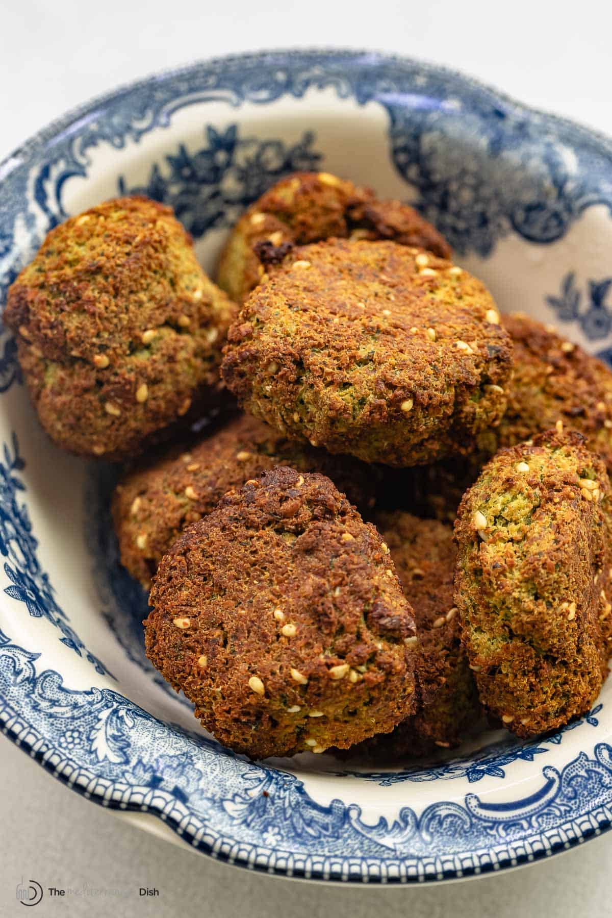 several air fryer falafel patties in a blue and white bowl.