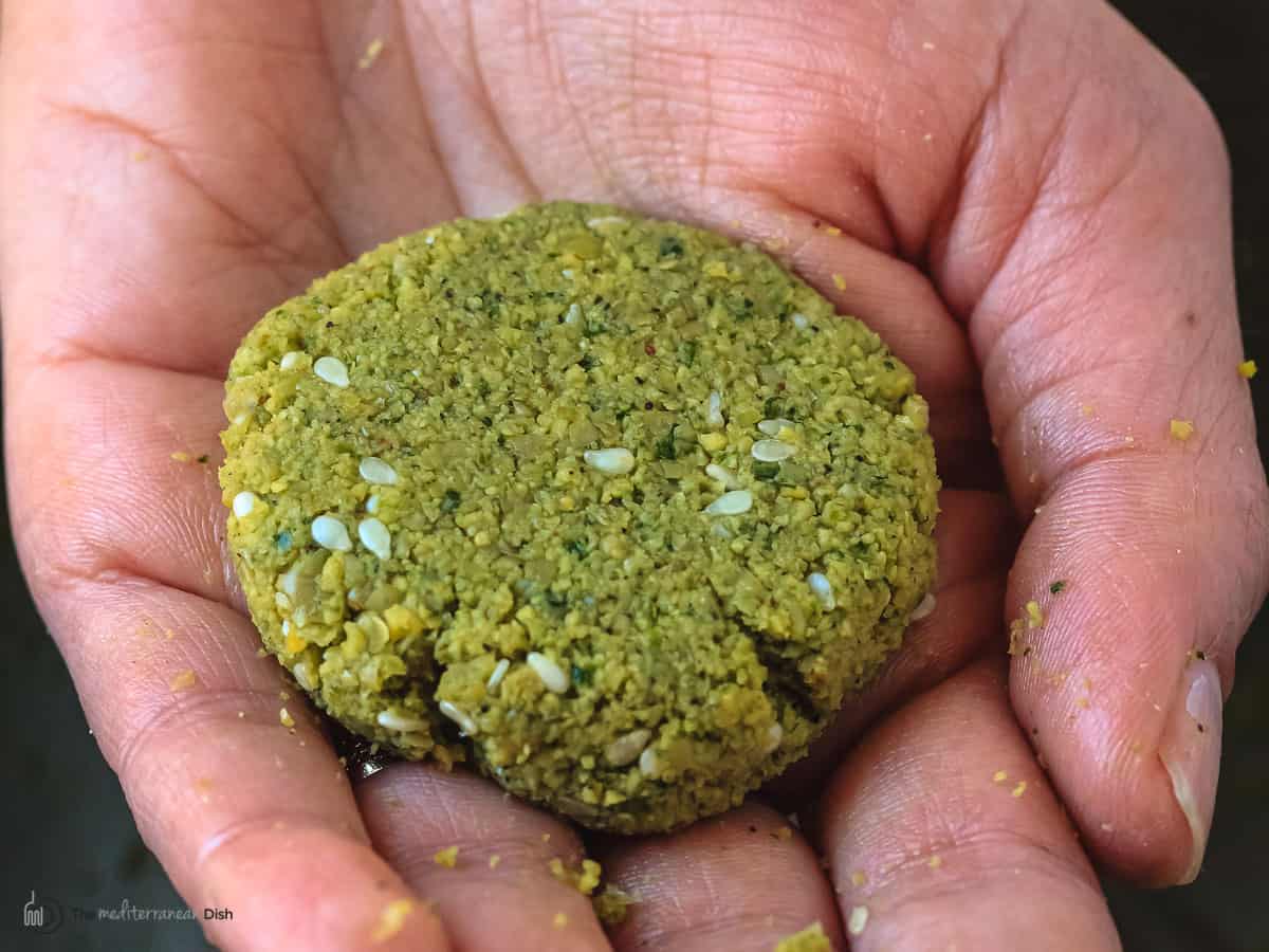 one falafel patty in a woman's palm.
