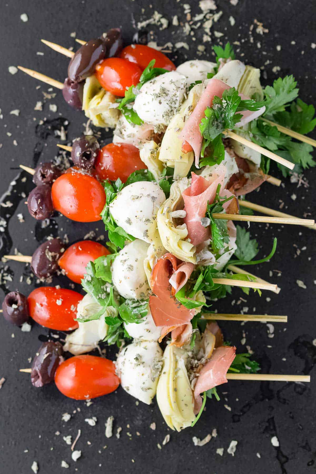 several assembled antipasti skewers sprinkled with dried herbs.