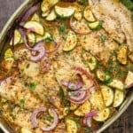 recipe for flounder including baked flounder fillets and vegetables in a baking dish.