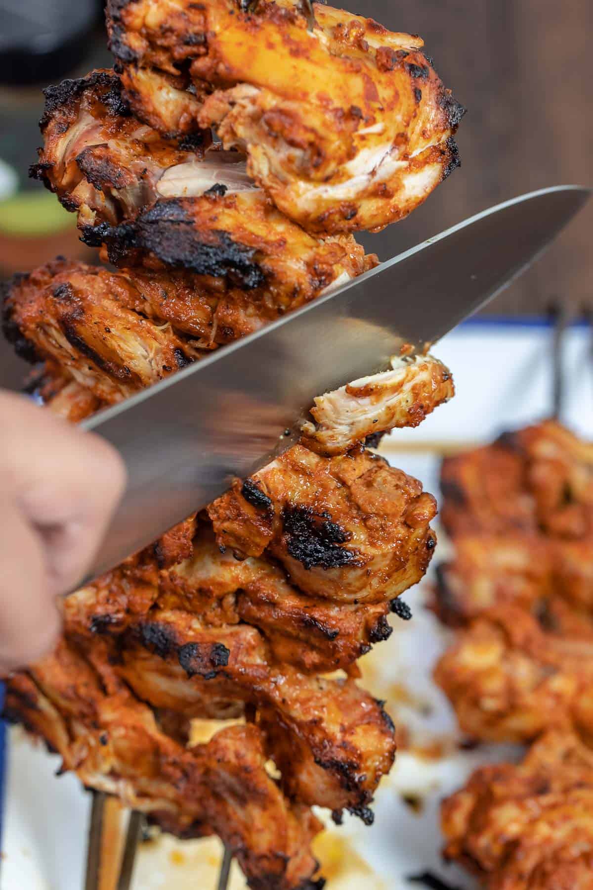 chicken doner kebab being carved with a sharp knife.