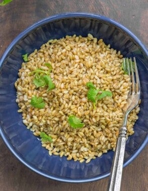 A bowl of cooked freekeh with parsley sprinked on top.