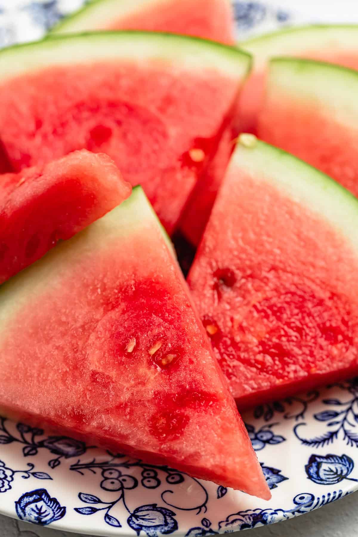 close up of watermelon slices on a blue and white plate.