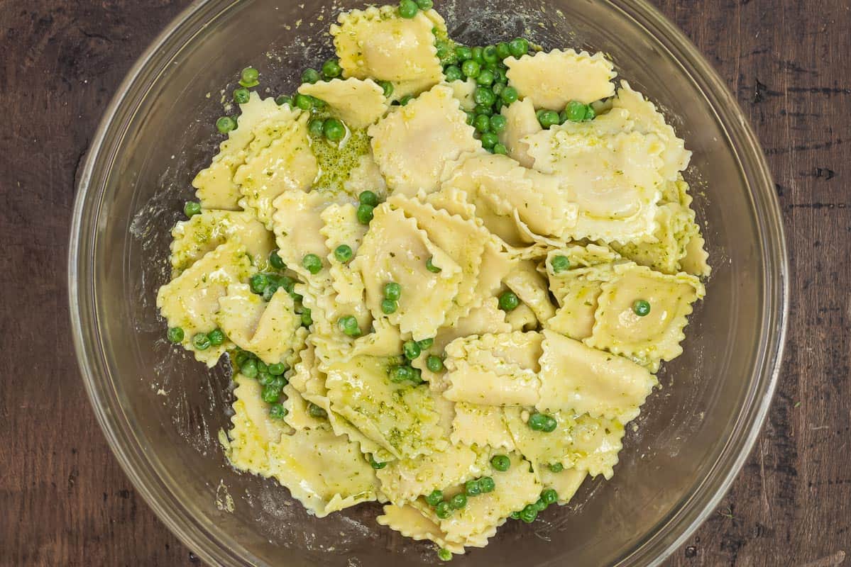 peas and ravioli tossed with basil pesto in a large bowl.