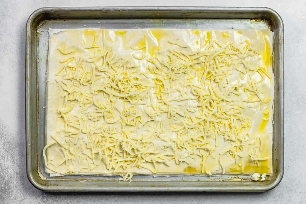 layers of phyllo dough brushed with olive oil and sprinkled with some cheese.