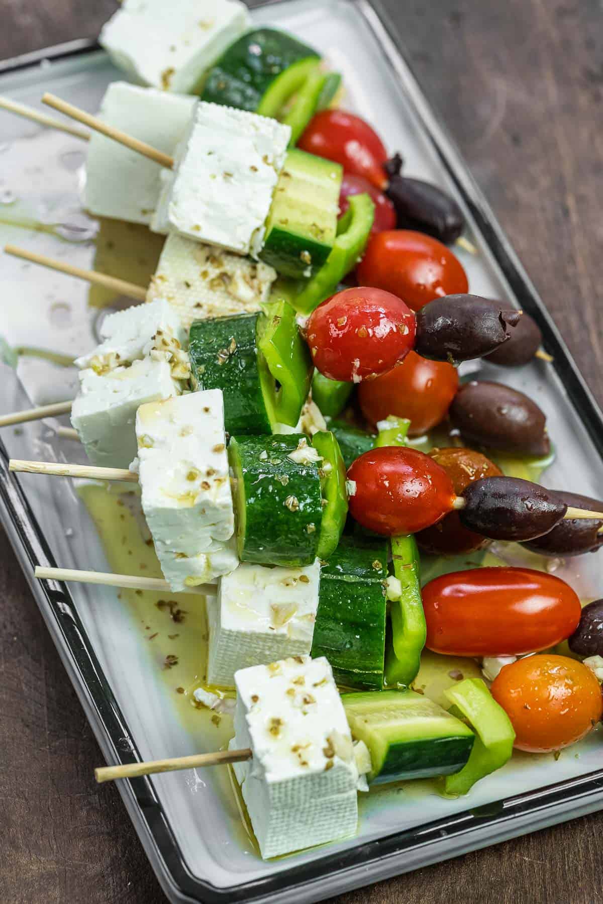Greek salad skewers with olives, grape tomatoes, bell peppers, cucumber, and feta cheese.