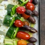 close up of Greek salad kebabs with Greek-style dressing.